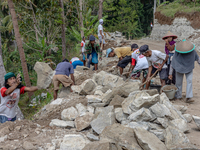 Villagers, including men and women, work together (gotong royong) to renovate a broken village road at Kebumen, Central Java, Indonesia on A...