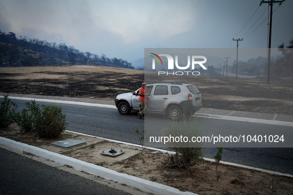 A volunteer forest firefighter stands in his car and the burnt forest can be seen from behind. Mount Parnitha 22/8/23 