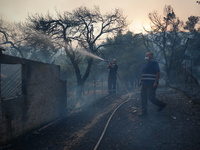 Firemans trying to extinguish the fire from a burning house. Mount Parnitha 22/8/23 (