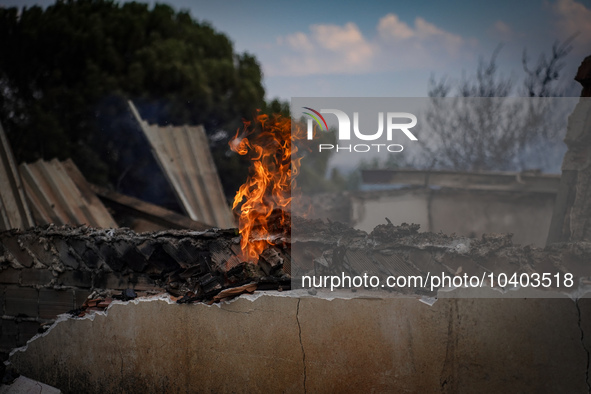 A flame is leaping from the wall of a fire-damaged house on Mount Parnitha in Athens, Greece, on  August 23, 2023 