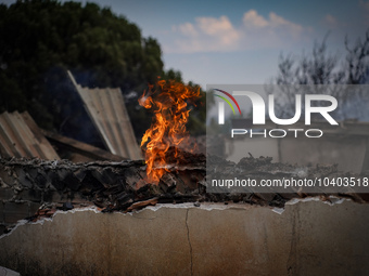 A flame is leaping from the wall of a fire-damaged house on Mount Parnitha in Athens, Greece, on  August 23, 2023 (