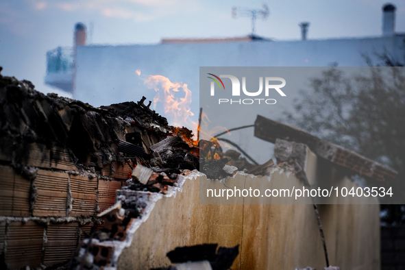 A flame is leaping from the wall of a fire-damaged house on Mount Parnitha in Athens, Greece, on  August 23, 2023 