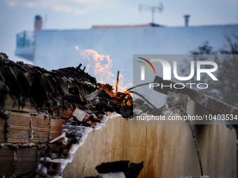 A flame is leaping from the wall of a fire-damaged house on Mount Parnitha in Athens, Greece, on  August 23, 2023 (