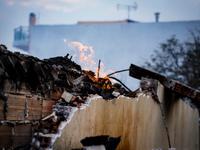 A flame is leaping from the wall of a fire-damaged house on Mount Parnitha in Athens, Greece, on  August 23, 2023 (