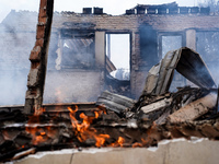 A flame is leaping from the wall of a fire-damaged house on Mount Parnitha in Athens, Greece, on  August 23, 2023 (