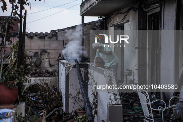 A resident is extinguishing the last flames from his house on Mount Parnitha in Athens, Greece, on August 23, 2023 