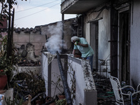 A resident is extinguishing the last flames from his house on Mount Parnitha in Athens, Greece, on August 23, 2023 (