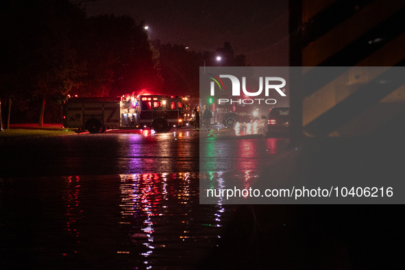 ROYAL OAK, MI - AUGUST 24, 2023: Firemen from the Royal Oak Fire Department blockade a flooded street after a severe thunderstorm that inclu...