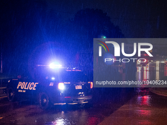 ROYAL OAK, MI - AUGUST 24, 2023: Royal Oak police officers and firemen from the Royal Oak Fire Department blockade a flooded street after a...