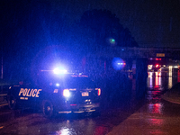 ROYAL OAK, MI - AUGUST 24, 2023: Royal Oak police officers and firemen from the Royal Oak Fire Department blockade a flooded street after a...