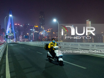 CHONGQING, CHINA - NOVEMBER 18, 2022 - (FILE) The picture shows a delivery man passing by Qiansimen Bridge. Chongqing, China, November 18, 2...