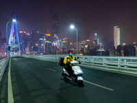 CHONGQING, CHINA - NOVEMBER 18, 2022 - (FILE) The picture shows a delivery man passing by Qiansimen Bridge. Chongqing, China, November 18, 2...