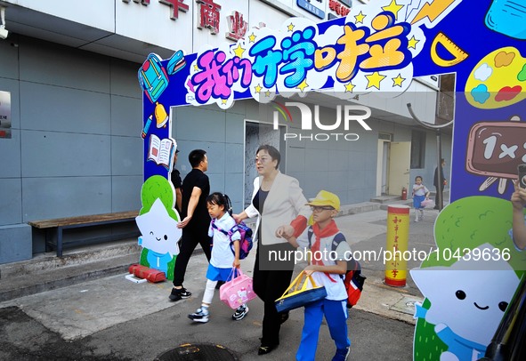 Children walk into a primary school in Beijing, China, September 1, 2023. On the same day, the new semester of primary and secondary schools...