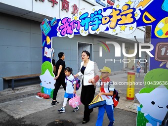 Children walk into a primary school in Beijing, China, September 1, 2023. On the same day, the new semester of primary and secondary schools...