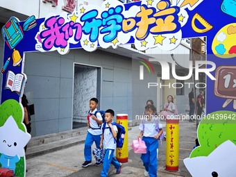 Children walk into a primary school in Beijing, China, September 1, 2023. On the same day, the new semester of primary and secondary schools...