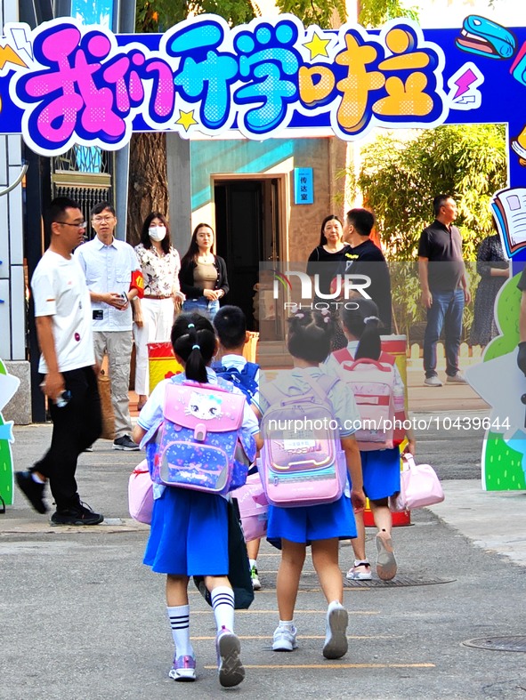 Children walk into a primary school in Beijing, China, September 1, 2023. On the same day, the new semester of primary and secondary schools...