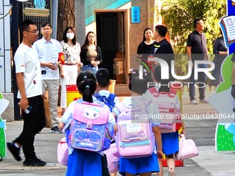 Children walk into a primary school in Beijing, China, September 1, 2023. On the same day, the new semester of primary and secondary schools...