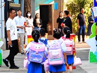 Children walk into a primary school in Beijing, China, September 1, 2023. On the same day, the new semester of primary and secondary schools...