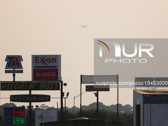 A firefighting aircraft is seen in the distance through the wildfire haze near Huntsville in Walker County, Texas.  (