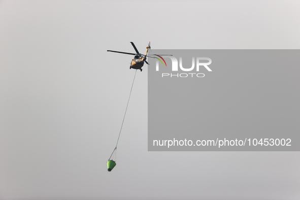 Helicopters help with the fire suppression effort during a large and fast-moving wildfire in Walker County, Texas on September 2, 2023.  