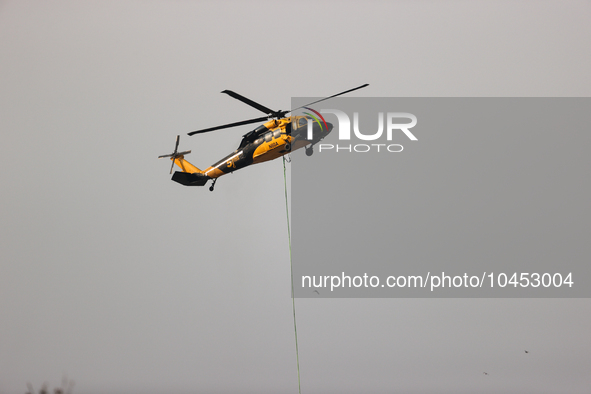 Helicopters help with the fire suppression effort during a large and fast-moving wildfire in Walker County, Texas on September 2, 2023.  