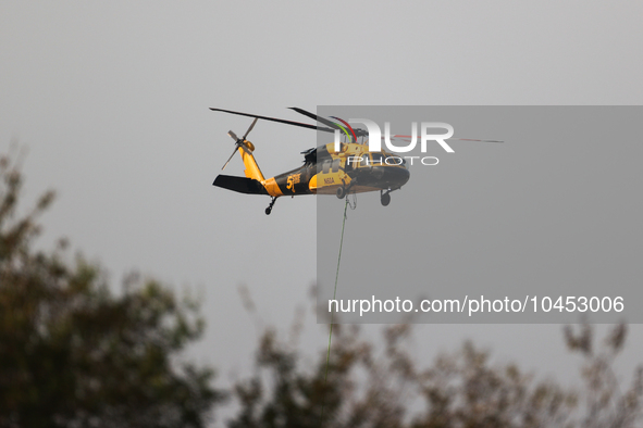 Helicopters help with the fire suppression effort during a large and fast-moving wildfire in Walker County, Texas on September 2, 2023.  