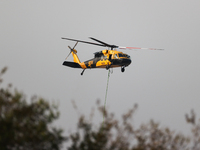 Helicopters help with the fire suppression effort during a large and fast-moving wildfire in Walker County, Texas on September 2, 2023.  (