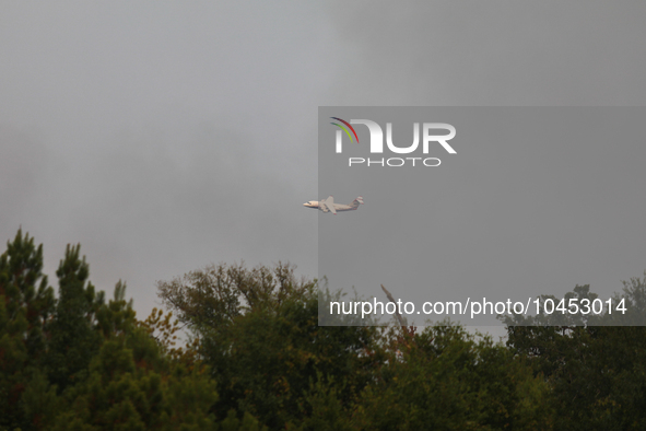 A firefighting aircraft passes through smoke from a wildfire in Walker County, Texas on September 2, 2023.  