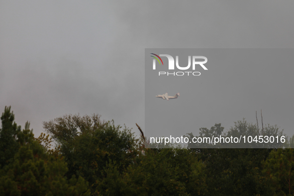 A firefighting aircraft passes through smoke from a wildfire in Walker County, Texas on September 2, 2023.  