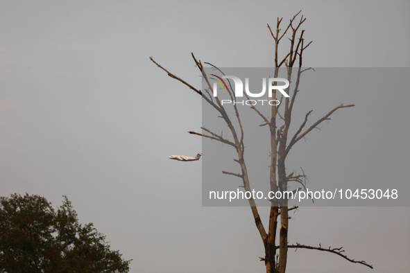 A firefighting aircraft passes through smoke from a wildfire in Walker County, Texas on September 2, 2023.  