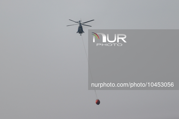 Helicopters help with the fire suppression effort during a large and fast-moving wildfire in Walker County, Texas on September 2, 2023.  