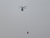 Helicopters help with the fire suppression effort during a large and fast-moving wildfire in Walker County, Texas on September 2, 2023.  (