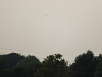 A firefighting aircraft is seen in the distance through the wildfire haze near Huntsville in Walker County, Texas.  (