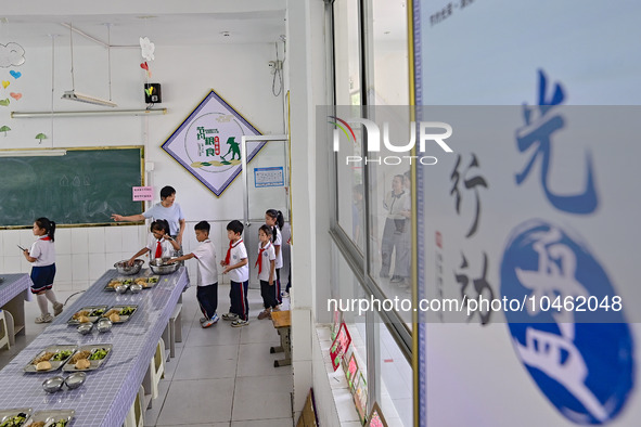 Students receive cutlery for lunch at Yanghe Primary School in Gaoliu town, Qingzhou city, East China's Shandong province, Sept 4, 2023. 