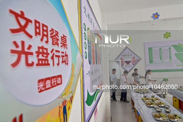 Students receive cutlery for lunch at Yanghe Primary School in Gaoliu town, Qingzhou city, East China's Shandong province, Sept 4, 2023. 