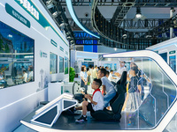  A child experiences virtual driving of an electric vehicle at the State Grid booth at the 2023 SMART CHINA EXPO in Chongqing, China, Sept....