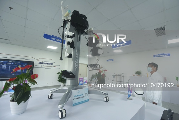 A medical worker watches a one-leg favoring rehabilitation robot exercise at the accessory center of Hangzhou Rehabilitation Hospital in Han...