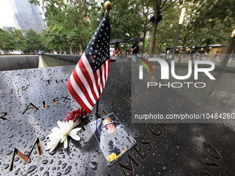 Flowers and US flags are laid on one of the South Pool panels at World Trade Center Memorial to commemorate the 9/11 Anniversary in New York...