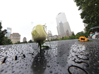 Flowers and US flags are laid on one of the North Pool panels at World Trade Center Memorial to commemorate the 9/11 Anniversary in New York...