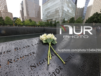 Flowers and US flags are laid on one of the North Pool panels at World Trade Center Memorial to commemorate the 9/11 Anniversary in New York...