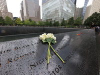 Flowers and US flags are laid on one of the North Pool panels at World Trade Center Memorial to commemorate the 9/11 Anniversary in New York...