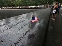 Flowers and US flags are laid on one of the North Pool panels at World Trade Center Memorial to commemorate the 9/11 Anniversary in New York...