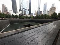 Flowers and US flags are laid on one of the North Pool panels at World Trade Center Memorial to commemorate the 9/11 Anniversary in New York...