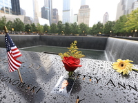 Flowers and US flags are laid on one of the North Pool panels at World Trade Center Memorial to commemorate the 9/11 Anniversary in New York...