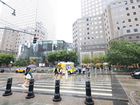 Pedestrians cross West Side to Brookfield Place across from the World Trade Center Memorial site and One World Trade Center in New York, New...