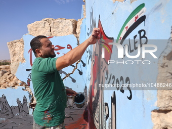 Graffiti artist Aziz Al-Asmar paints a painting on the wall of a destroyed house in the town of bench rural Idlib in solidarity with the vic...