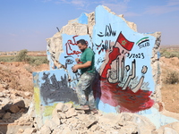 Graffiti artist Aziz Al-Asmar paints a painting on the wall of a destroyed house in the town of bench rural Idlib in solidarity with the vic...