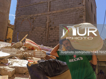 A man retrieves blankets from his destroyed house in Amizmiz, just a few dozen kilometers away from the epicenter of the earthquake that sho...