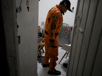 Hector Mendez, better known as El Chino, head and founder of the Azteca Topos International Rescue Brigade, gets ready at his home before tr...