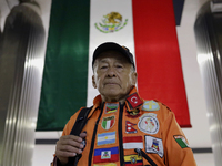 Hector Mendez, better known as El Chino, head and founder of the Azteca Topos International Rescue Brigade, in front of a Mexican flag insid...